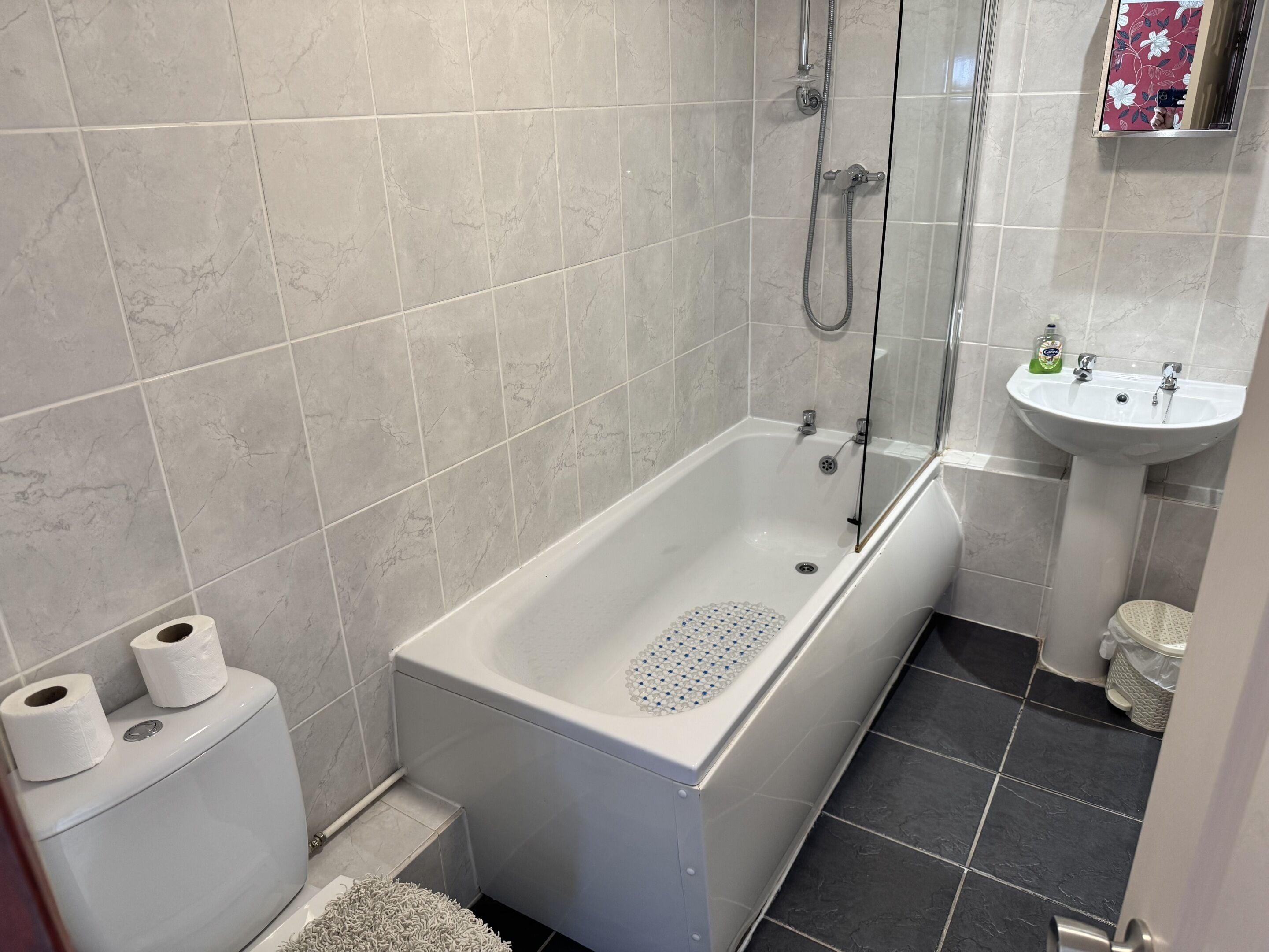 A bathroom with a bathtub, toilet, and sink.