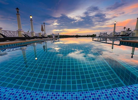 Una piscina al aire libre, sillones reclinables de piscina