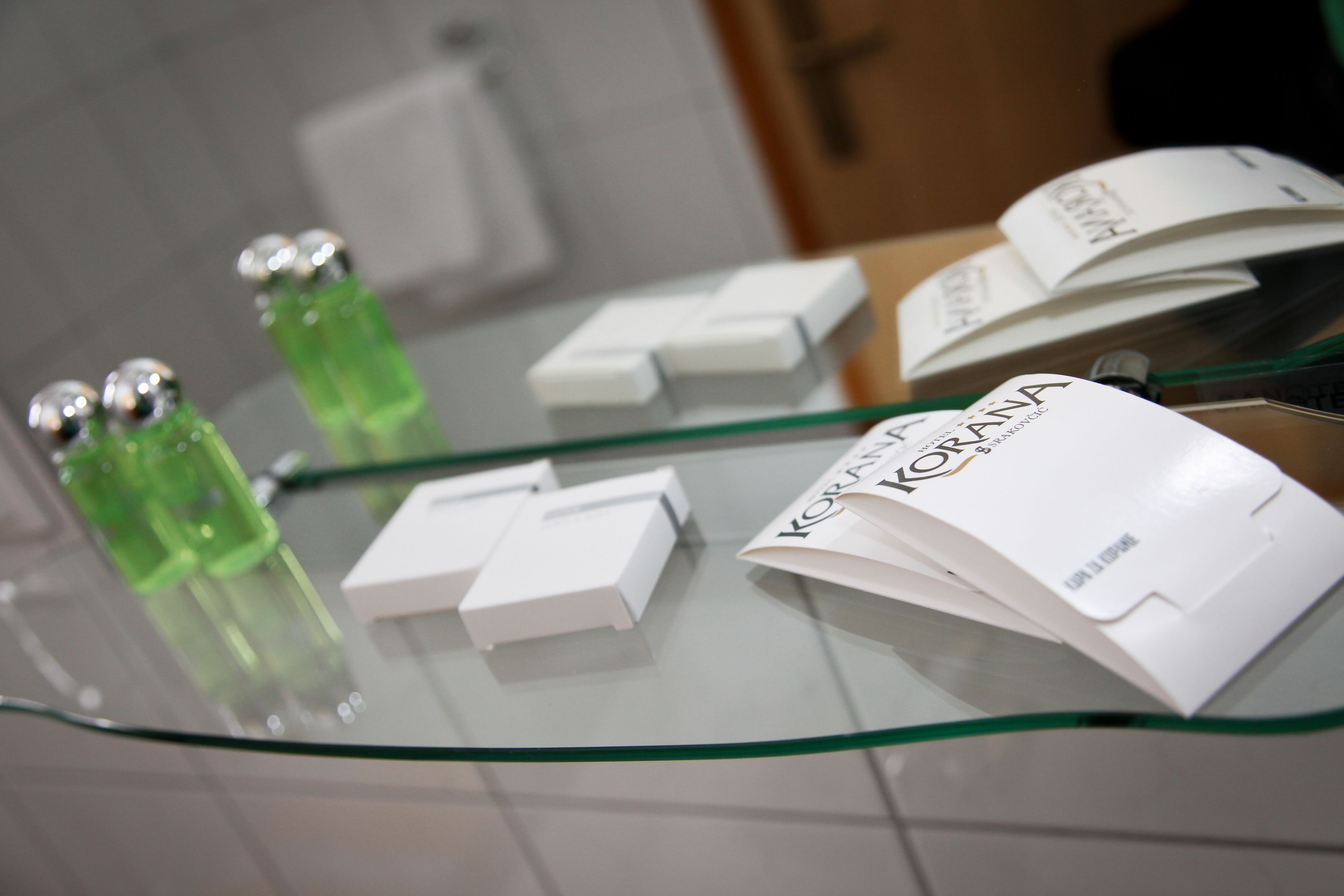 A glass display table with various items including bottles and boxes, likely in a retail or hotel setting.