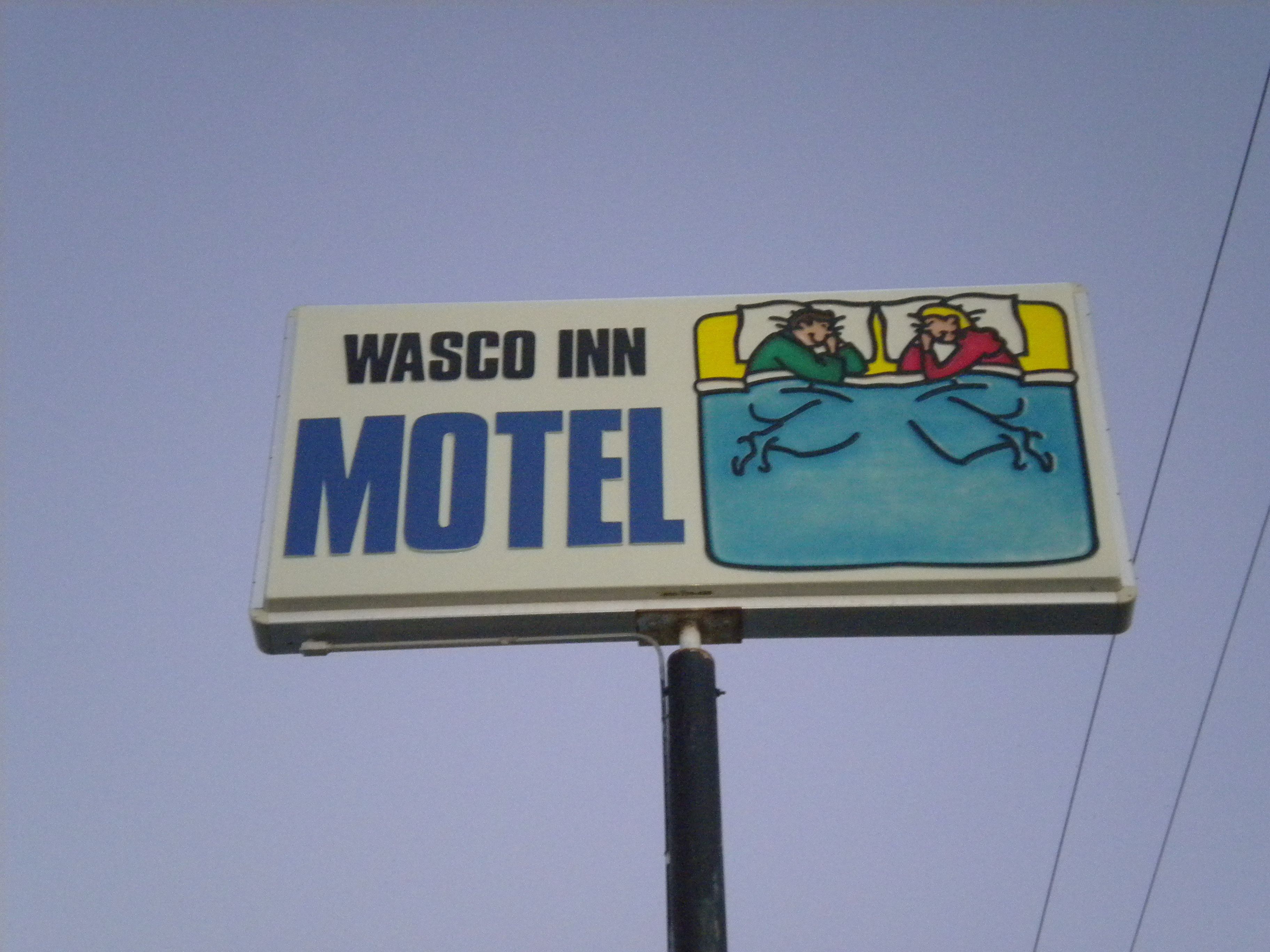 A Wasco Inn Motel sign with a depiction of two people in bed.