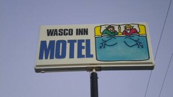 A Wasco Inn Motel sign with a depiction of two people in bed.