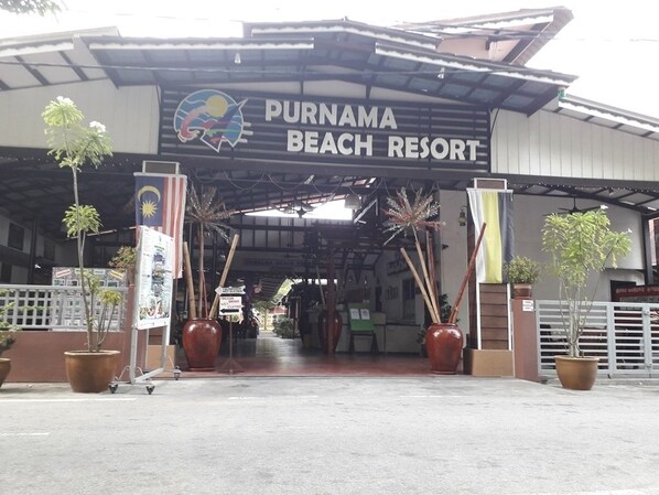 The entrance to Purnama Beach Resort with a covered walkway, potted plants, and a sign displaying the resort's name. - Purnama Beach Resort (Pangkor Island)