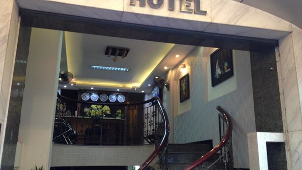 A hotel entrance with a staircase, a reception desk, and a clock on the wall. - Sao Nam Hotel - Bui Vien Walking Street (Ho Chi Minh City)