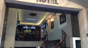 A hotel entrance with a staircase, a reception desk, and a clock on the wall. - Sao Nam Hotel - Bui Vien Walking Street (Ho Chi Minh City)
