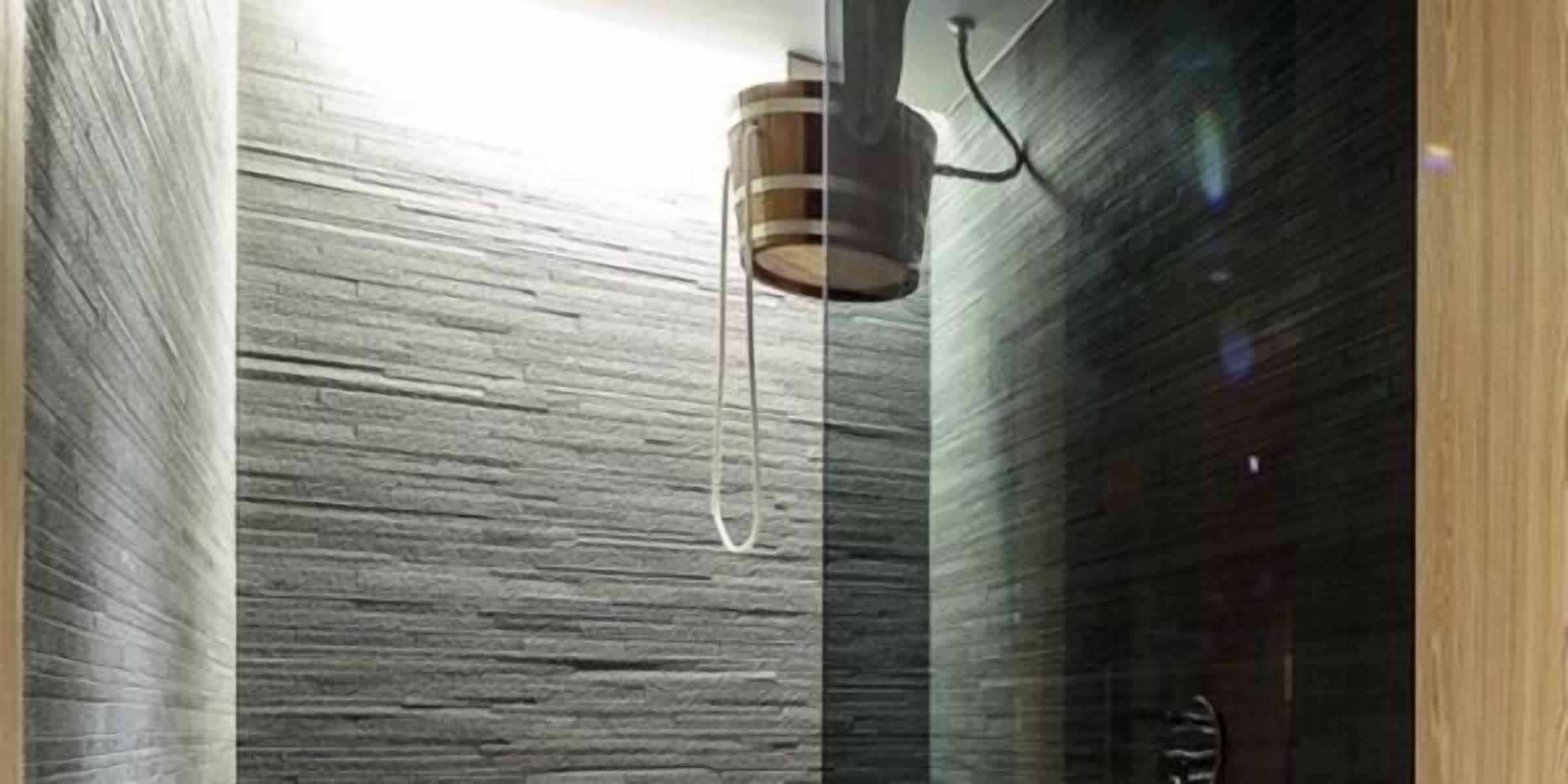 Un interior moderno con una pared texturizada y una lámpara colgante.