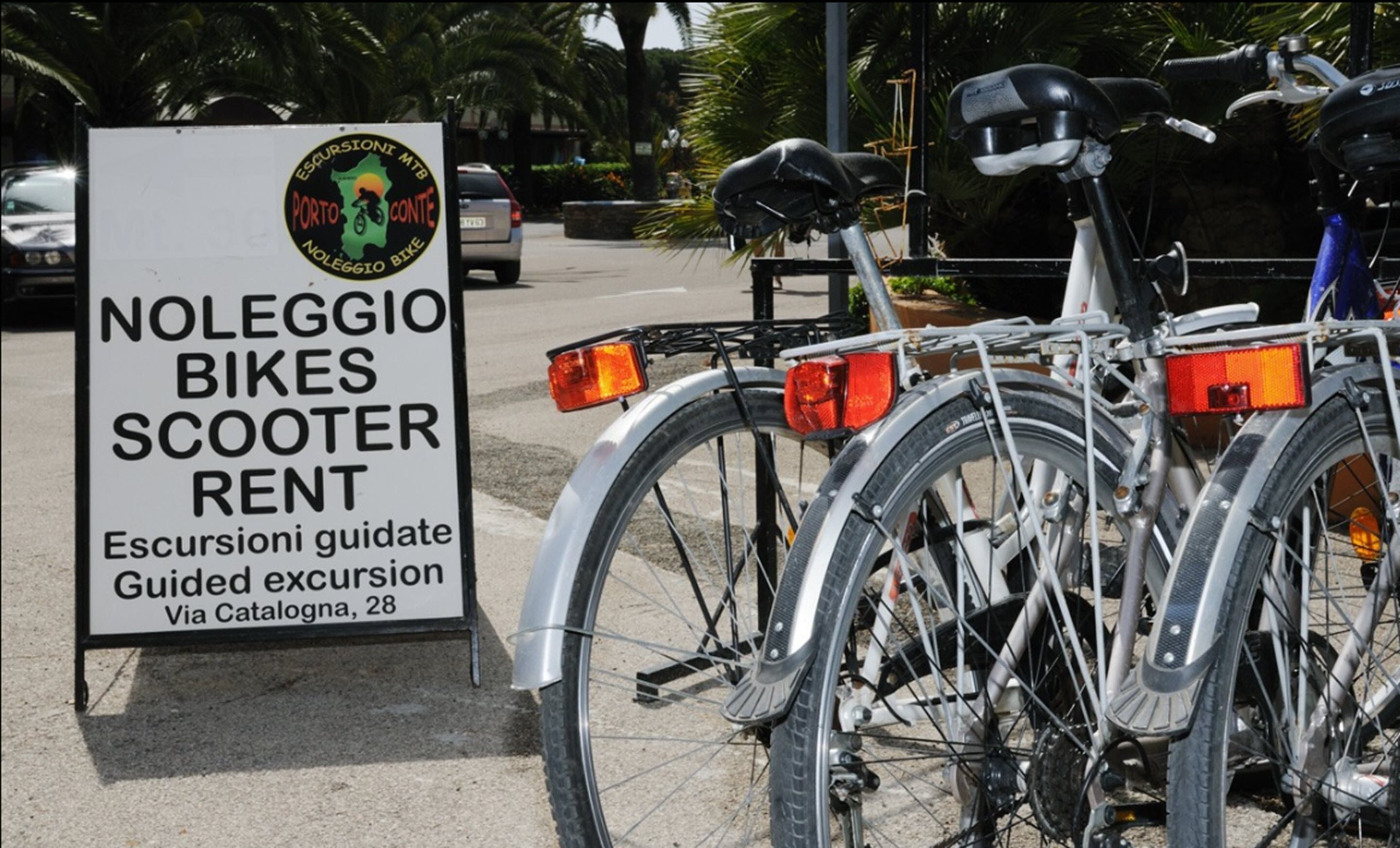 Schild für Noleggio Bikes & Scooter Rent, das geführte Ausflüge über Catalognia, 28, anzeigt.