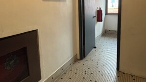 A hallway with a tiled floor, a fire alarm, a number 6 sign, and a 'KELUAR' exit sign. - Hotel J.B. (Johor Bahru)