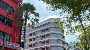 A multi-story hotel with balconies, a red building with a 'Link Postpaid' sign, and a 'Bangunan KAHIM' sign. - Hotel J.B. (Johor Bahru)