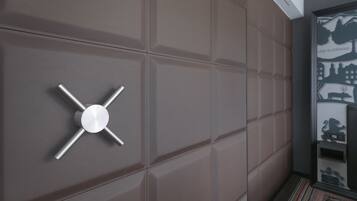 Ein modernes Interieur mit einem metallischen, kreuzförmigen Objekt an der Wand.