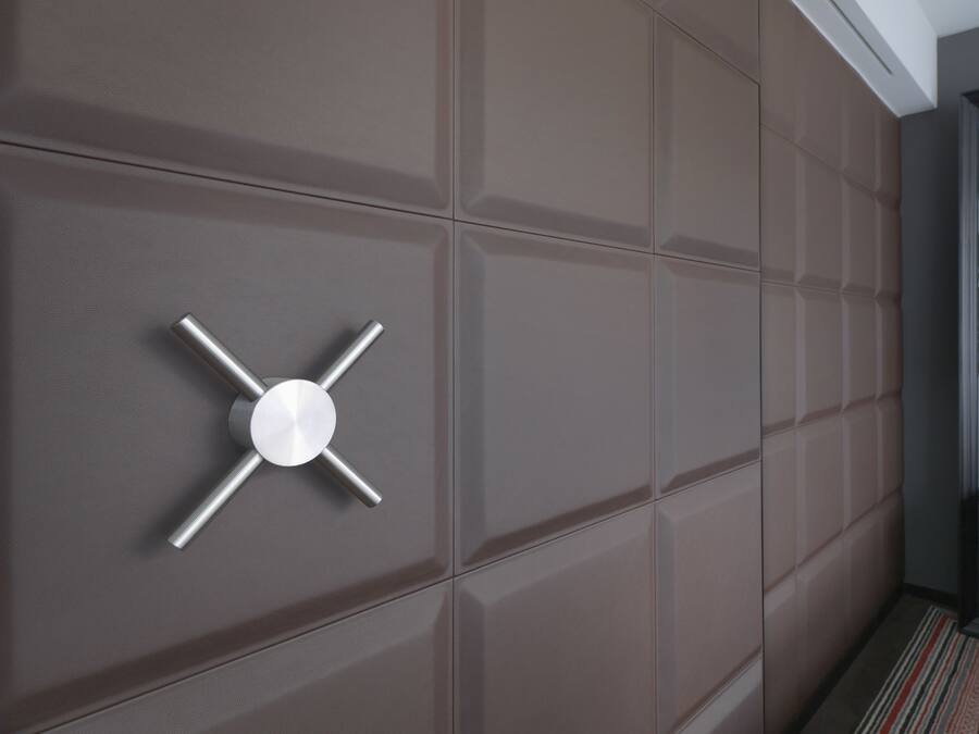 Ein modernes Interieur mit einem metallischen, kreuzförmigen Objekt an der Wand.