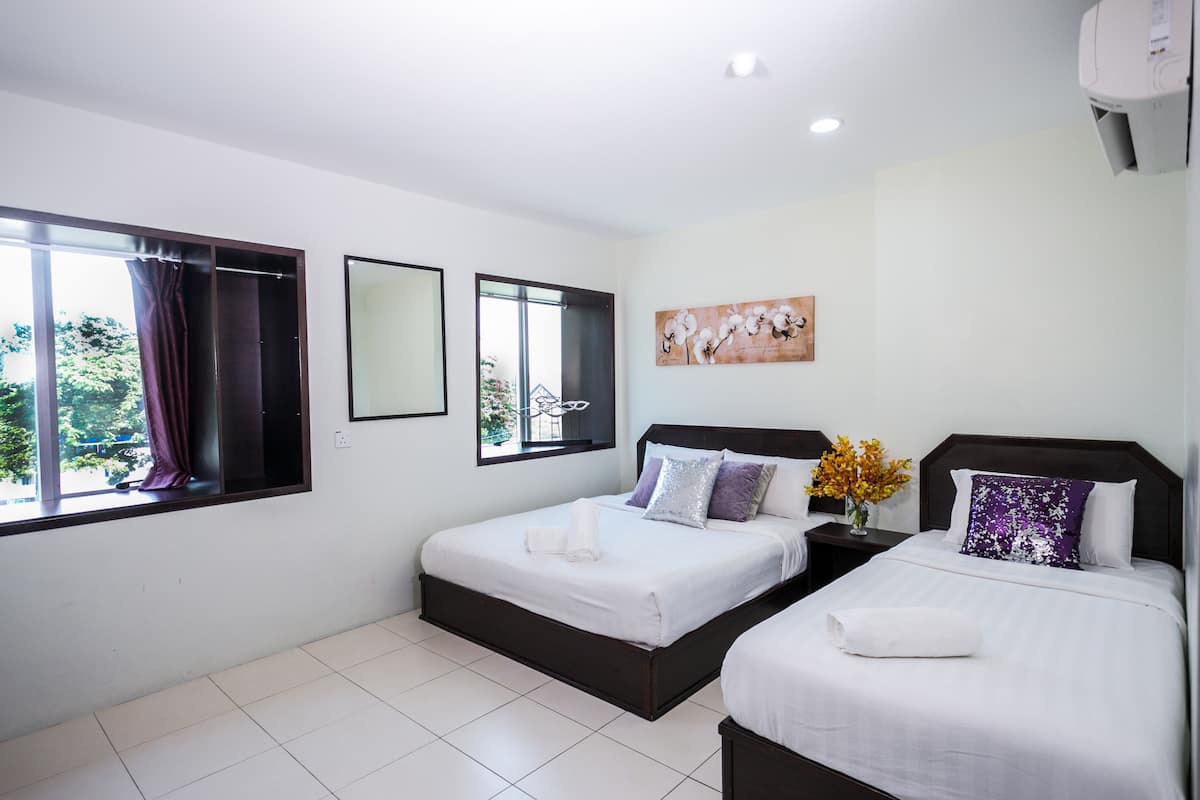 Habitación de hotel con dos camas, un ventanal con cortinas, un espejo en la pared y un cuadro.
