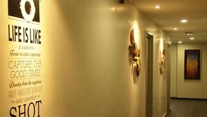 A hallway with a motivational quote on the wall, a camera graphic, and a door at the end. - M2 Hotel Melaka (Malacca City)