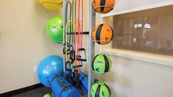 Un soporte de equipo de ejercicio montado en la pared, con varias pelotas de ejercicio y bandas de resistencia.