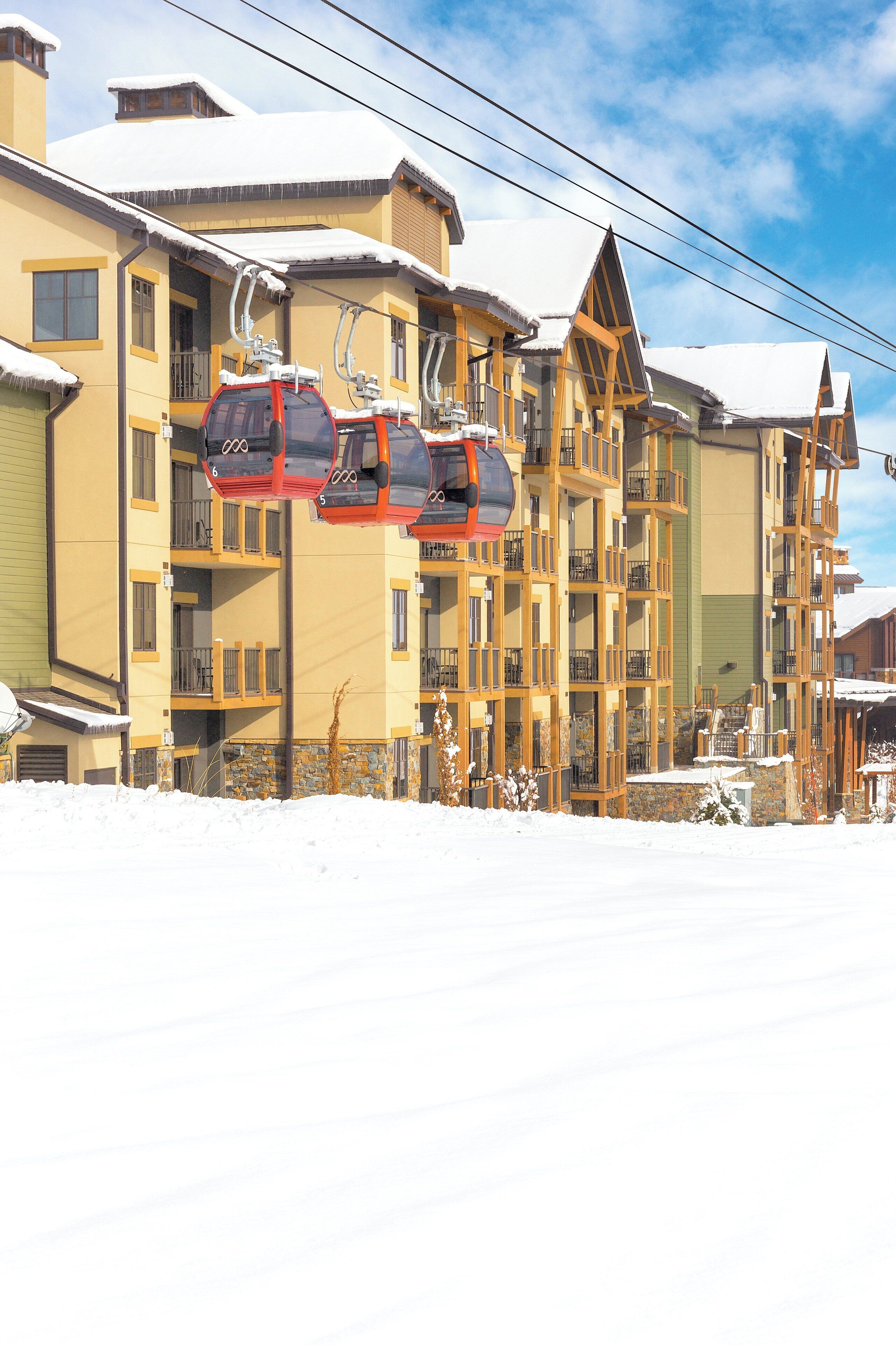 A multi-story building with a ski lift in front.