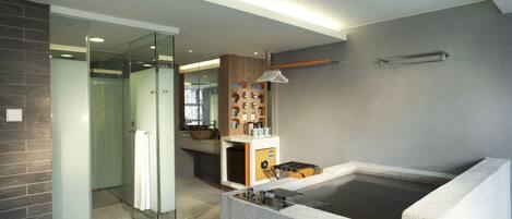 A modern bathroom with a glass shower, a bathtub, and a vanity area.