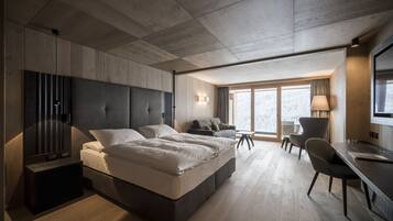 Un dormitorio moderno con una cama grande, un escritorio y una silla.