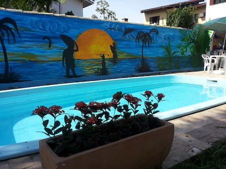 Una piscina al aire libre, sillones reclinables de piscina