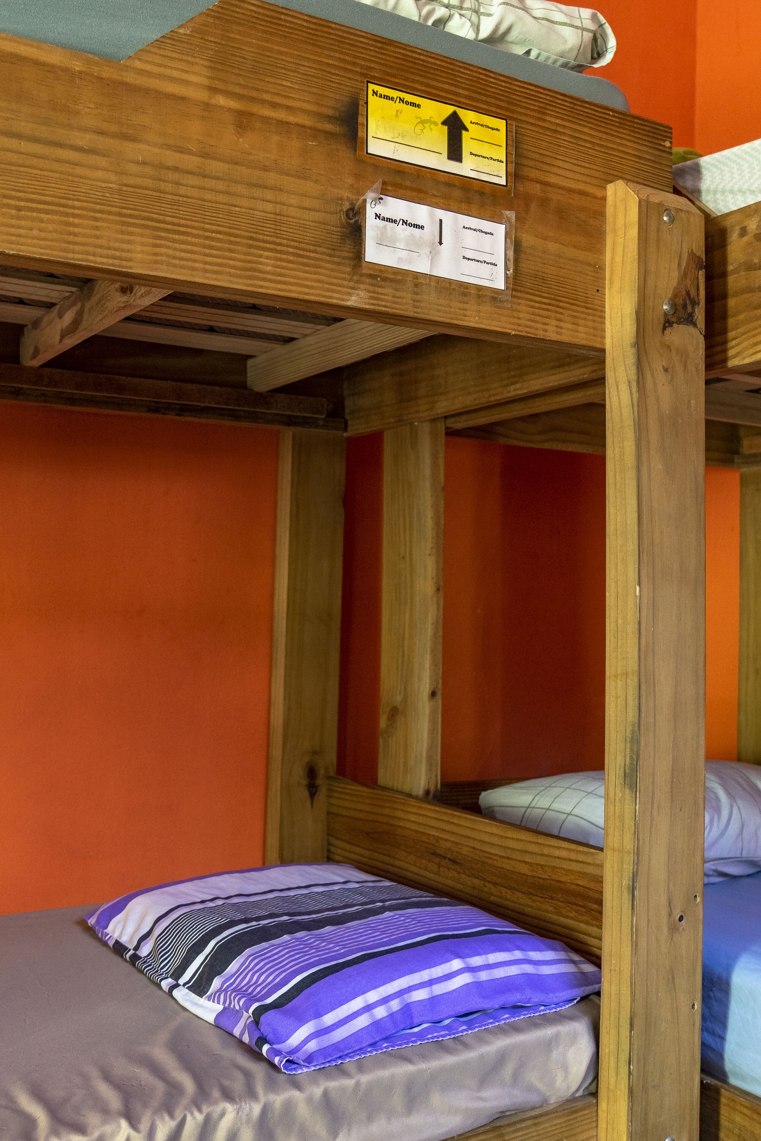 A bunk bed with a sign indicating the direction to the bathroom.