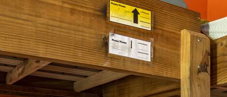 A bunk bed with a sign indicating the direction to the bathroom.