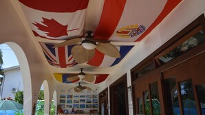 Techo con banderas, incluyendo la bandera canadiense y una bandera con un logotipo. Hay ventiladores de techo y una pared con un mapa.