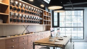 A modern office space with a wooden desk, drawers, and a wall-mounted electrical panel. - Art'otel Ximending Taipei (Taipei)