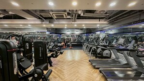 A gym with cardio equipment, weight machines, and a mirrored wall. - Art'otel Ximending Taipei (Taipei)