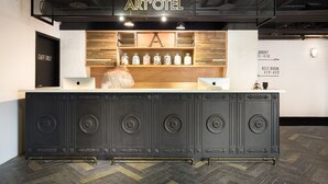 A reception desk with a sign reading "ART'OTEL," a wooden shelf with jars, and a "TAFF ONLY" door. - Art'otel Ximending Taipei (Taipei)