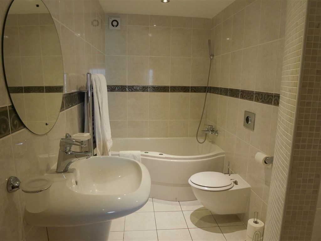 Un baño con lavamanos, inodoro y bañera.