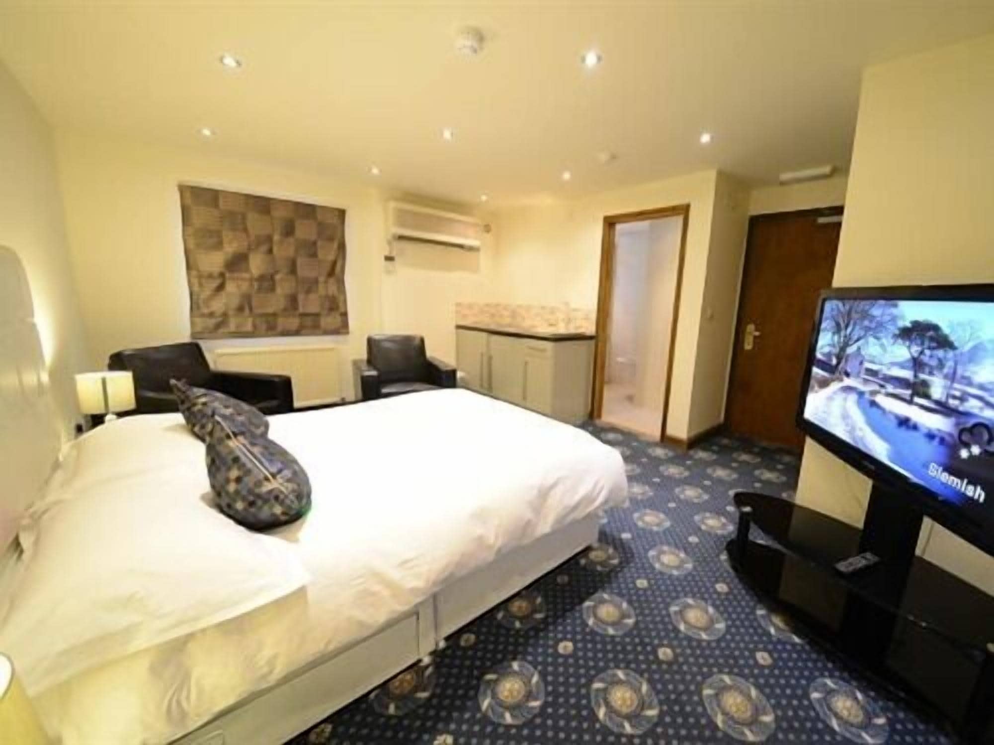 A hotel room with a bed, a television, a desk, and a chair.