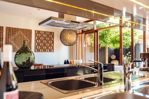 Una cocina moderna con una isla grande, electrodomésticos de acero inoxidable y vistas al exterior.