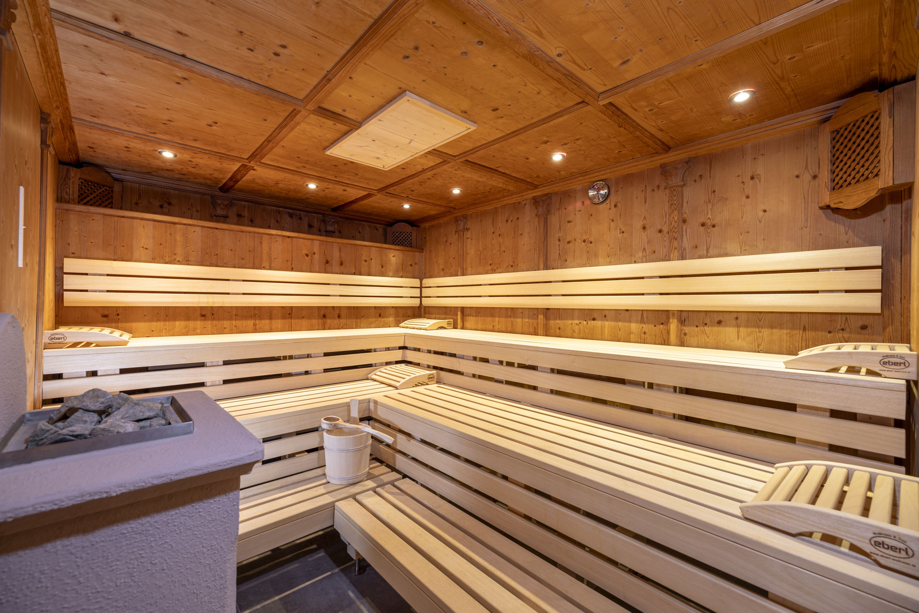A sauna with wooden benches and a stone basin.
