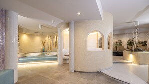 A spa area with a large bathtub, seating areas, and a view of a mountainous landscape. -  VALARA Alpine Art Hotel (Tux)