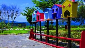 Colorful birdhouses on stands in a garden setting. - Master Bear Resort (Beinan)