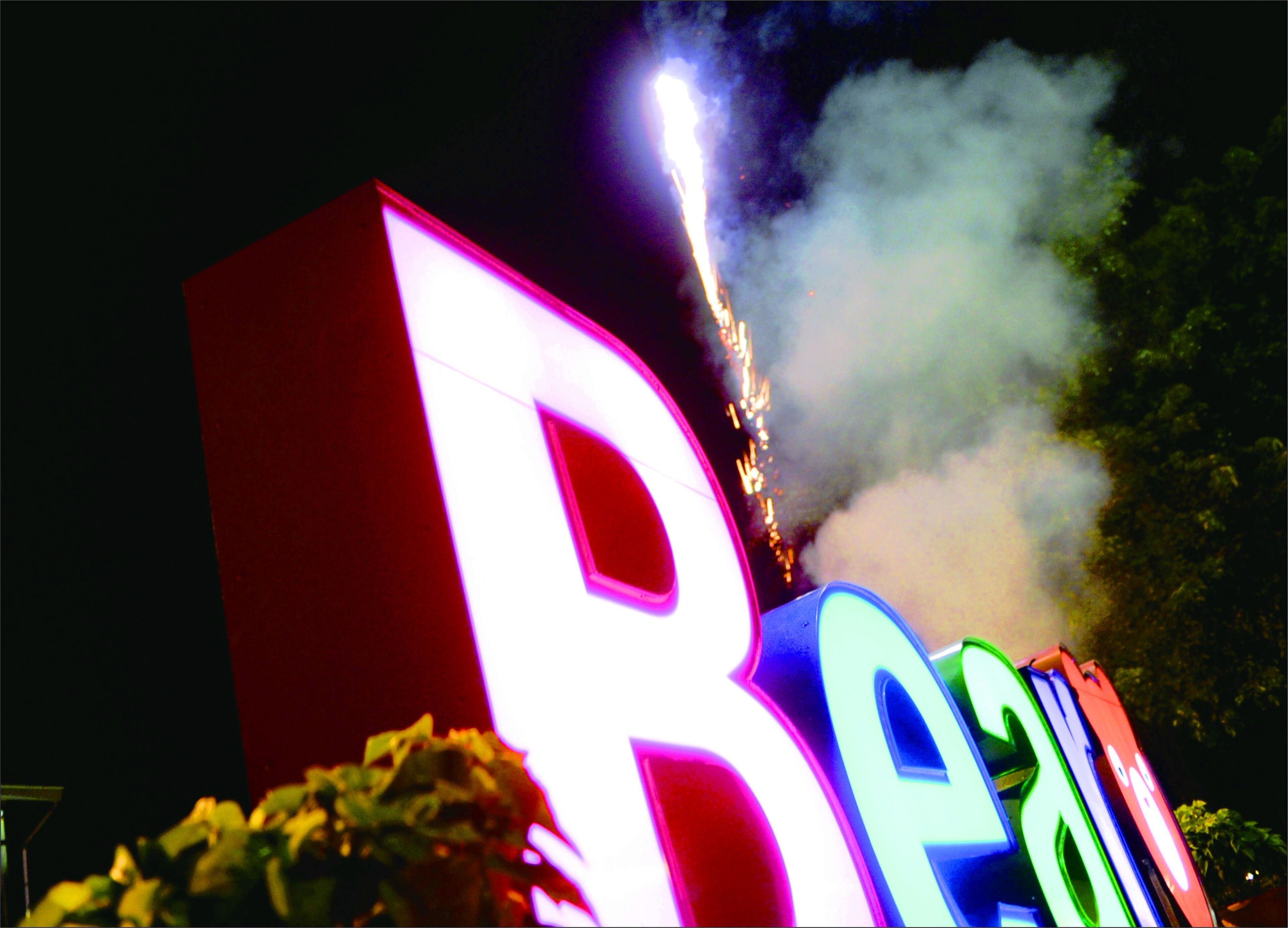 Illuminated letters spelling "BEAU" with a firework in the background.