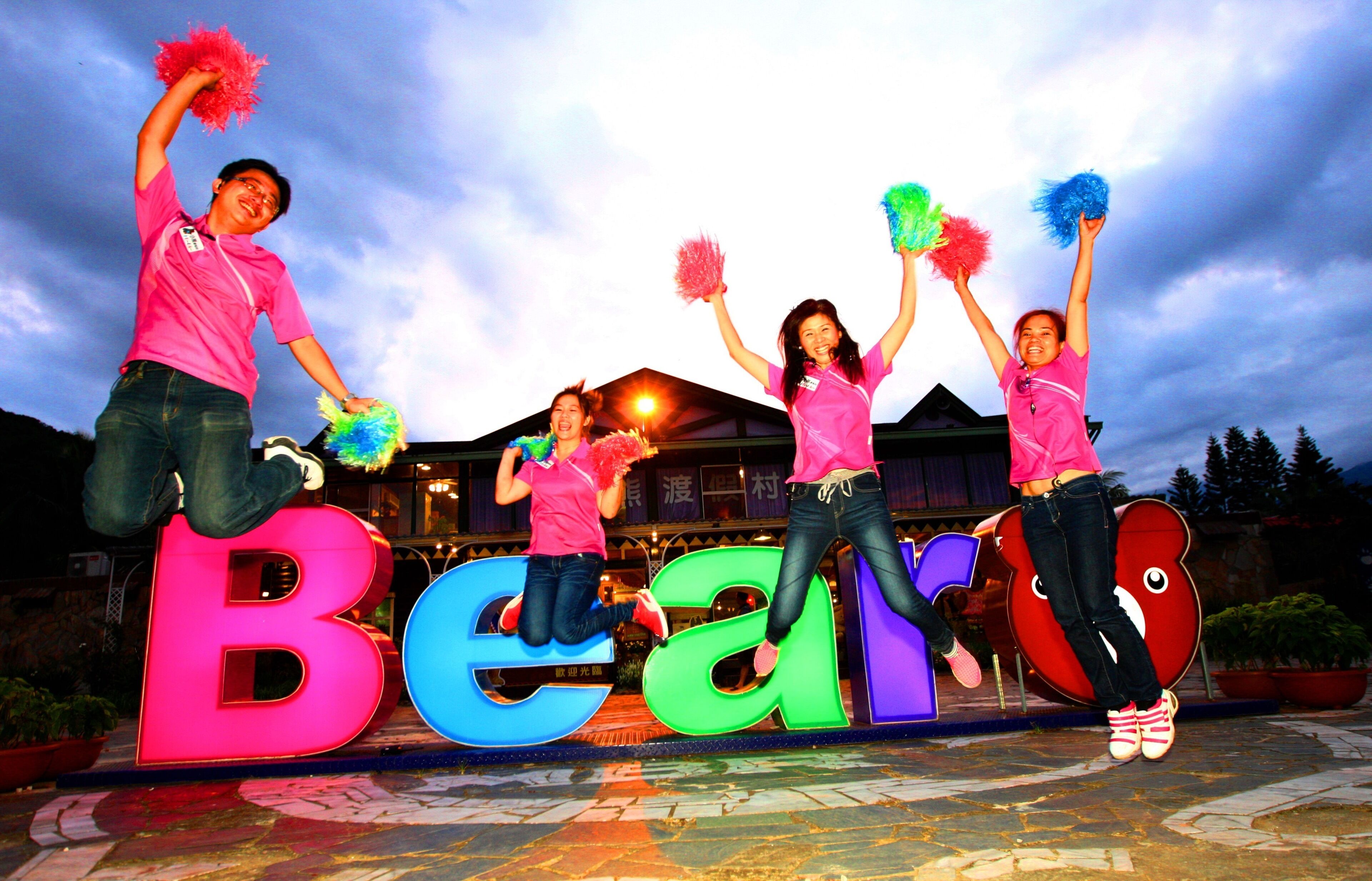 A group of cheerleaders performing on a stage with large illuminated letters spelling "Bear".