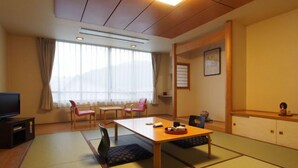 A traditional Japanese room with tatami flooring, a low table, and chairs. - Tofuya Ryokan (Yonezawa)