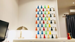 A room with a white desk, a lamp, a wall-mounted board with colorful figurines, and a black TV. - Grande Archivio Napoli 22 (Naples)