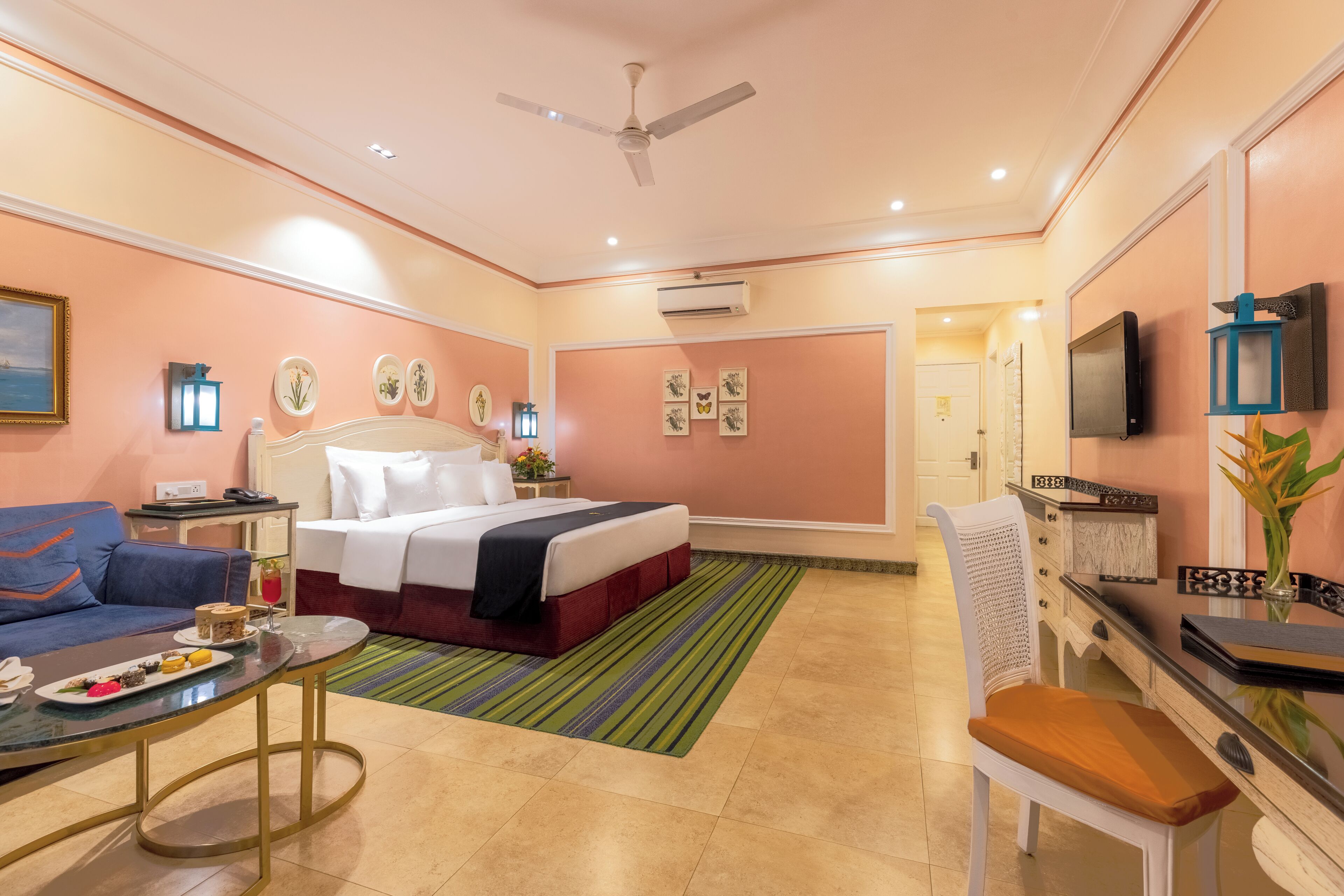 Una habitación de hotel con cama, sofá, escritorio y televisor.
