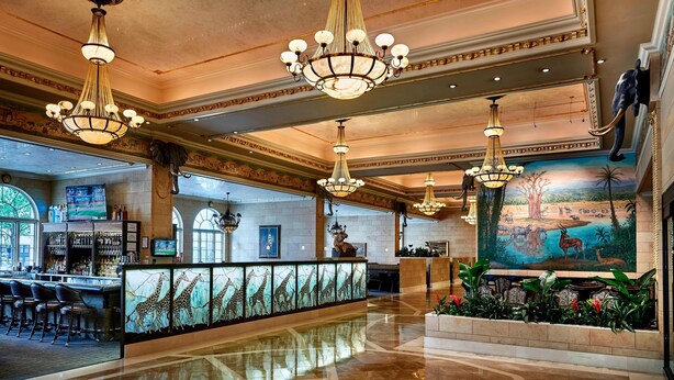 A lobby with chandeliers, a reception desk, a bar area, and a mural. - The Davenport Tower, Autograph Collection (Spokane)