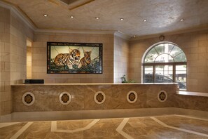 Eine Lobby mit einer großen Tiger-Mural, einem Empfangstresen und einem großen Bogenfenster.