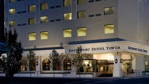The exterior of the Davenport Hotel Tower with a classic architectural design, featuring arched windows and a well-lit entrance. - The Davenport Tower, Autograph Collection (Spokane)