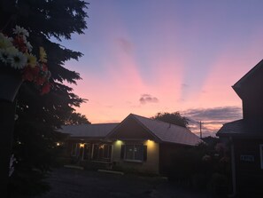 A building with a sloped roof, a porch with lights, and a sign that reads "OFFICE". - Big Bear Lodge (Alpena)