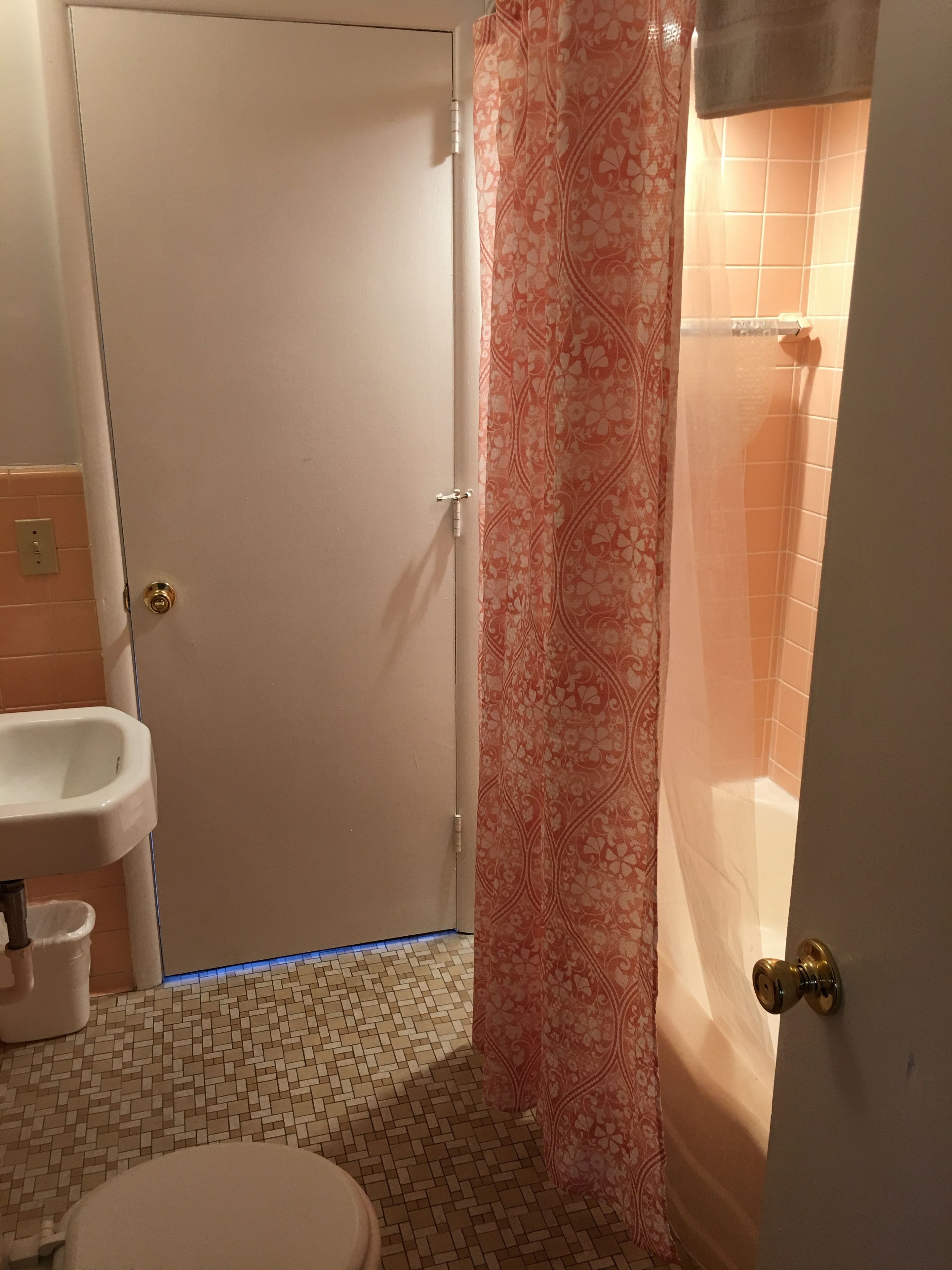 A bathroom with a toilet, sink, and shower area.