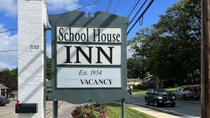 A sign for a School House Inn with a mailbox and a lamp post. - School House Inn (North Conway)