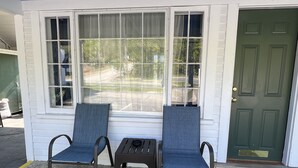 A room with two chairs and a table in front of a window. - School House Inn (North Conway)
