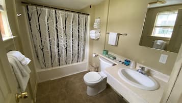 A bathroom with a toilet, sink, and shower curtain.