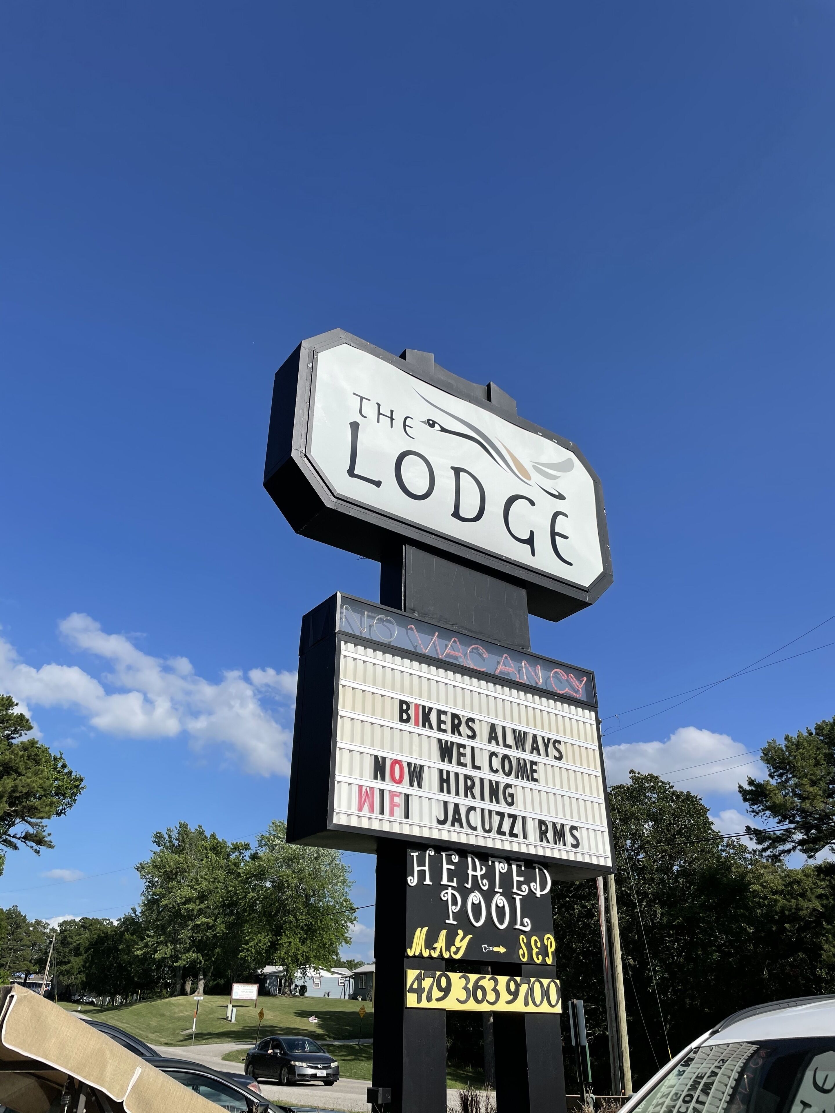Une enseigne pour «The Lodge», avec un panneau d’affichage indiquant les nouvelles offres d’emploi, la connexion Wi-Fi, la piscine chauffée et le jacuzzi.