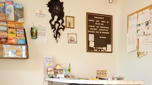 A reception desk with a marble top, a clock, and a 'No Smoking' sign. - Alpine Motel (Wisconsin Dells)