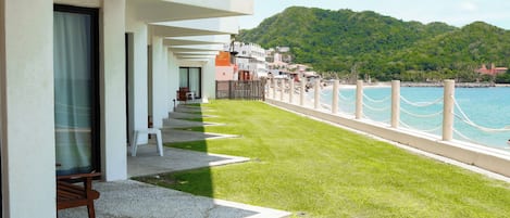 A balcony with a view of the sea and a mountain.