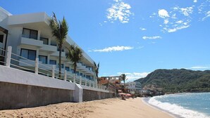Un hotel frente al mar con diseño moderno, con balcones y vistas al océano.
